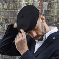 Model wearing black man's gatsby cap